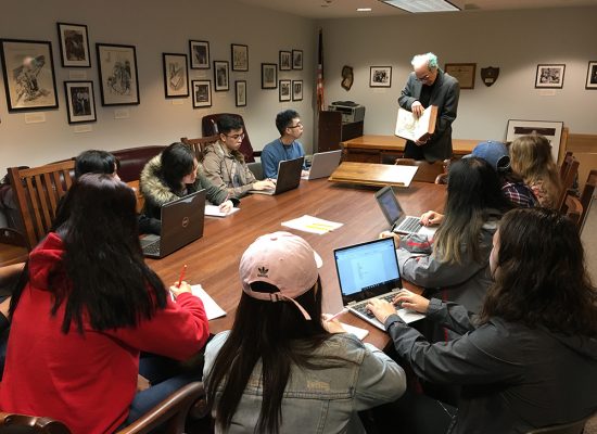 students viewing a book from Special Collections