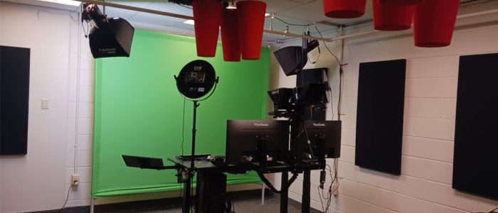 a room with a green screen and video recording equipment