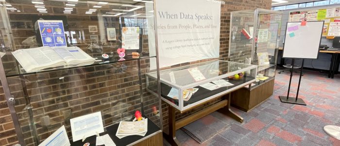 Display cases filled with various objects are lined up against the wall of a room.