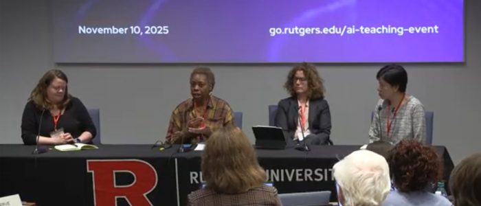 Four panelists sit at a table, facing an audience.