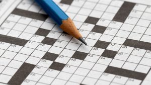 Pencil lying on a blank crossword puzzle