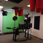 a room with a green screen and recording equipment