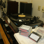 video reels and digital audio tapes lying on a table in front of a record player