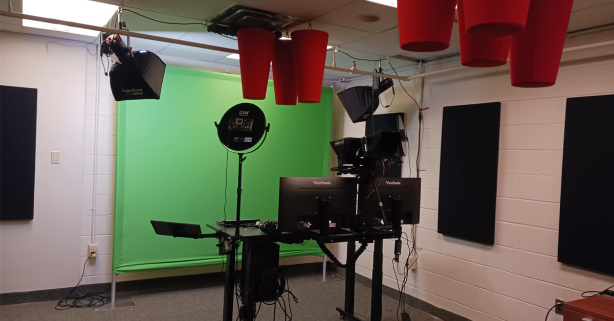 a room with a green screen and video recording equipment